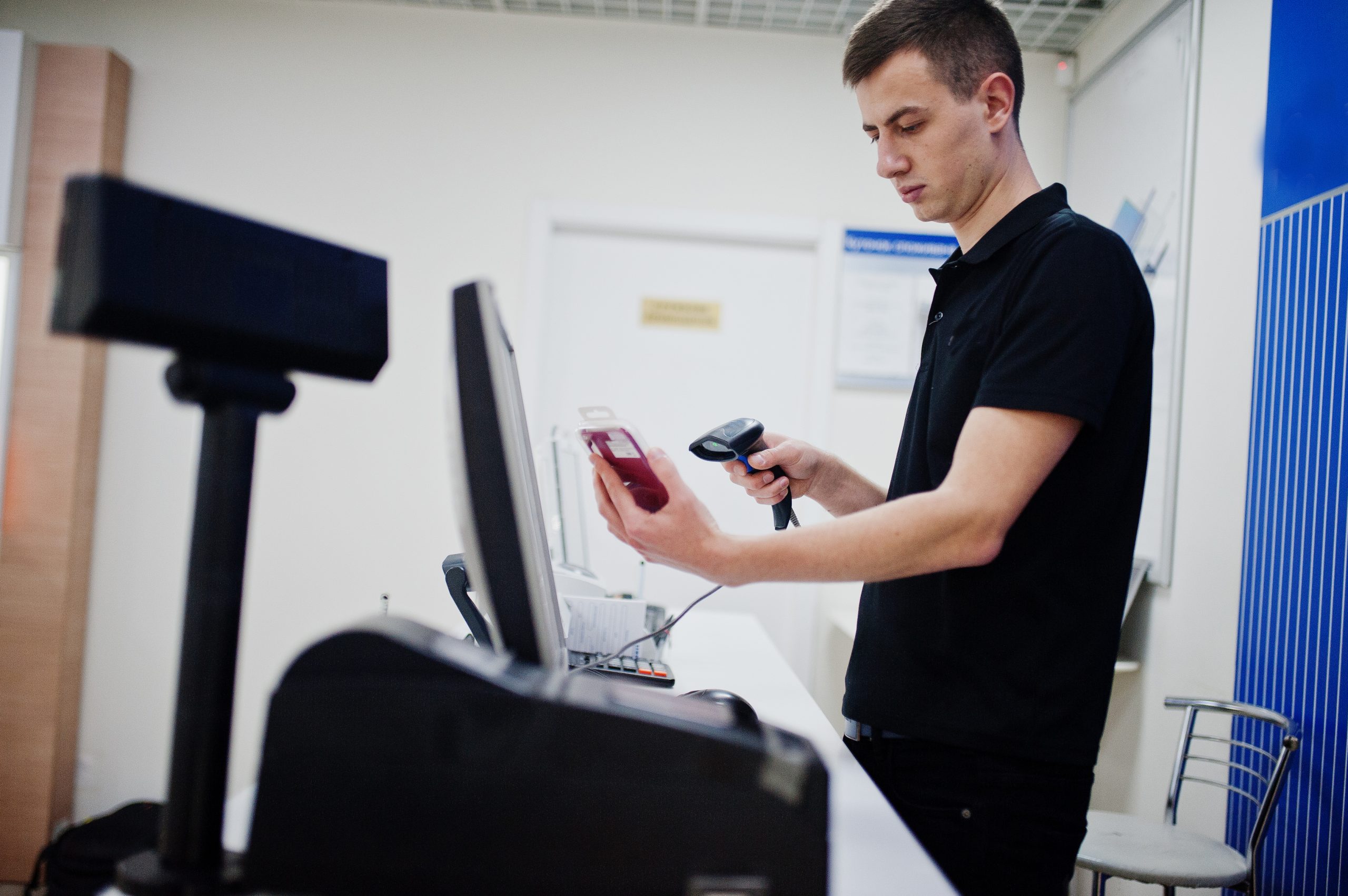 Medewerker scant een verpakt product met een handscanner bij een balie
